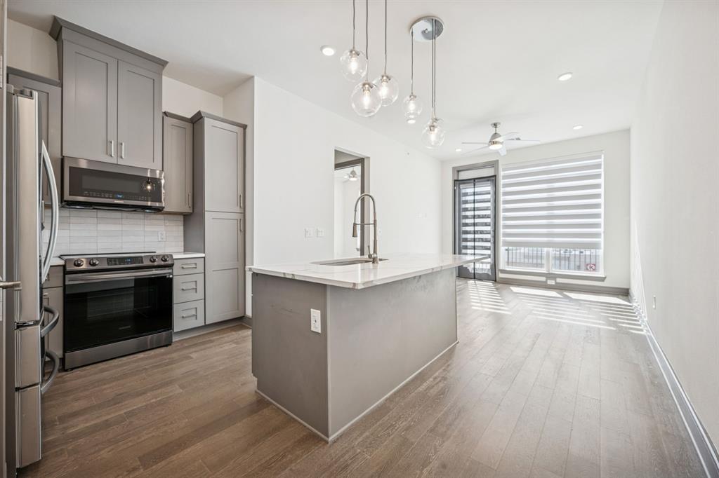 2700 Old Denton Road, Unit 4451 Carrollton, TX 75007 - Photo 6 of 38 a kitchen with stainless steel appliances granite countertop a stove a sink and a refrigerator