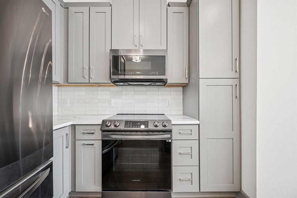 2700 Old Denton Road, Unit 4451 Carrollton, TX 75007 - Photo 7 of 38 a kitchen with white cabinets and stainless steel appliances