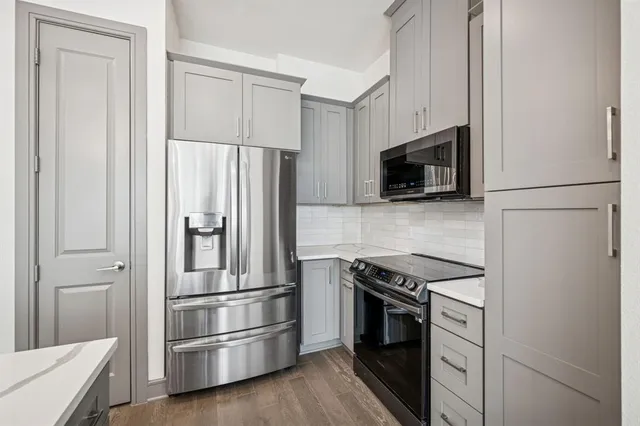 a kitchen with stainless steel appliances and refrigerator