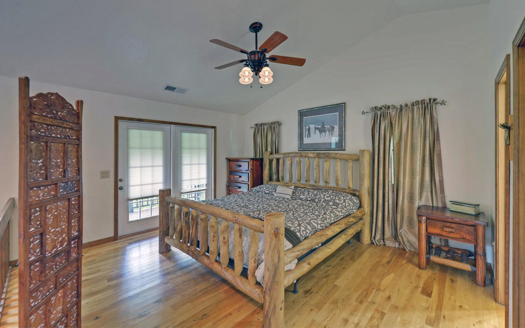 56 Waxwing Trail Murphy, NC 28906 - Photo 23 of 49 a bedroom with a bed and a chandelier