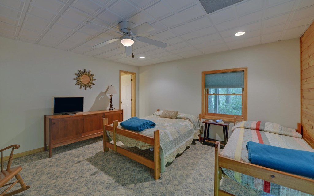 56 Waxwing Trail Murphy, NC 28906 - Photo 32 of 49 a spacious bedroom with a bed and a table in it