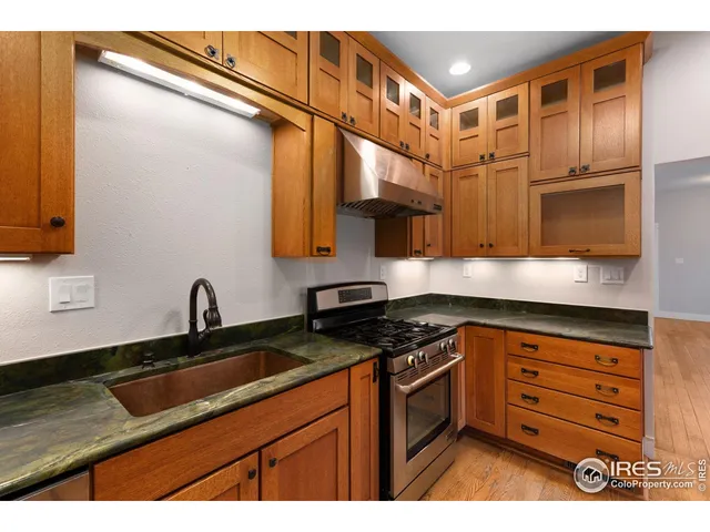 a kitchen with stainless steel appliances granite countertop a sink a stove and a microwave