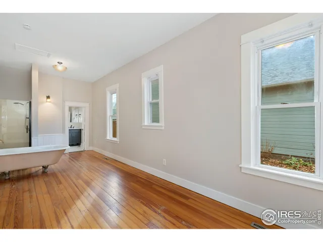 view of an empty room with wooden floor and a window