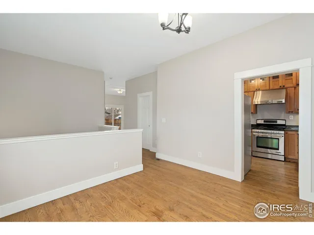 a view of kitchen with kitchen island wooden floor and stainless steel appliances