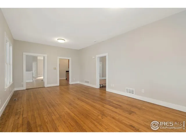 a view of an empty room with wooden floor
