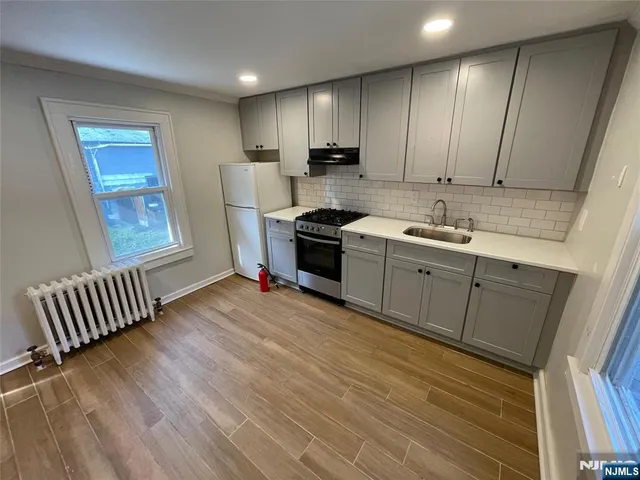 a kitchen with stainless steel appliances granite countertop a sink a stove and a refrigerator