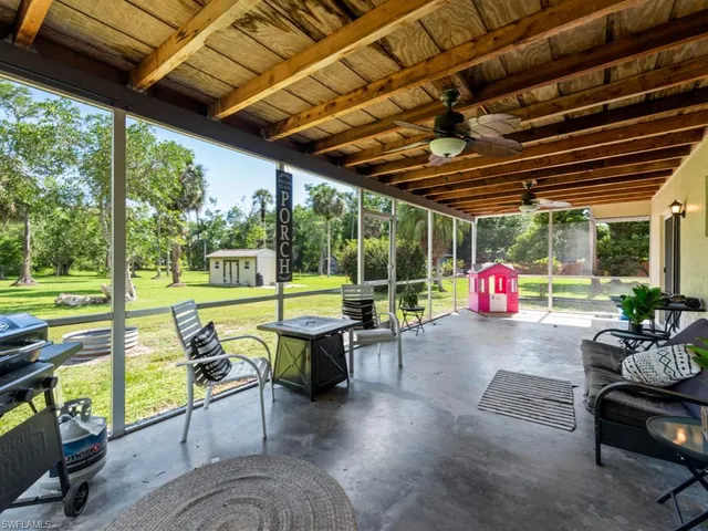 a living room with patio furniture and a backyard