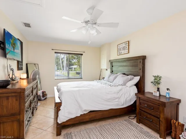 a bedroom with a bed window and a flat screen tv