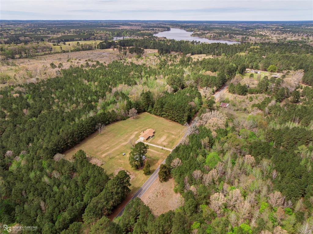 Drone / aerial view of a nearby body of water and a forest