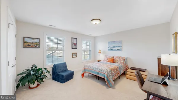 a bedroom with a bed and a potted plant