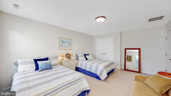 a bedroom with two beds and painting on the wall