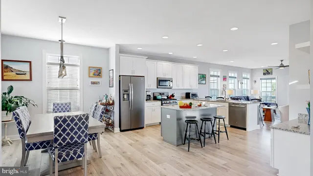 a view of a dining room and livingroom with furniture wooden floor a chandelier