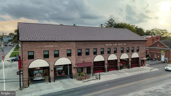 an aerial view of a house with swimming pool and large trees