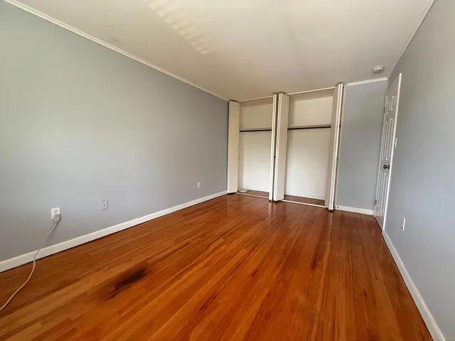a view of empty room with wooden floor