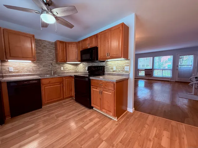 a kitchen with stainless steel appliances granite countertop a stove a sink dishwasher and a microwave oven with cabinets