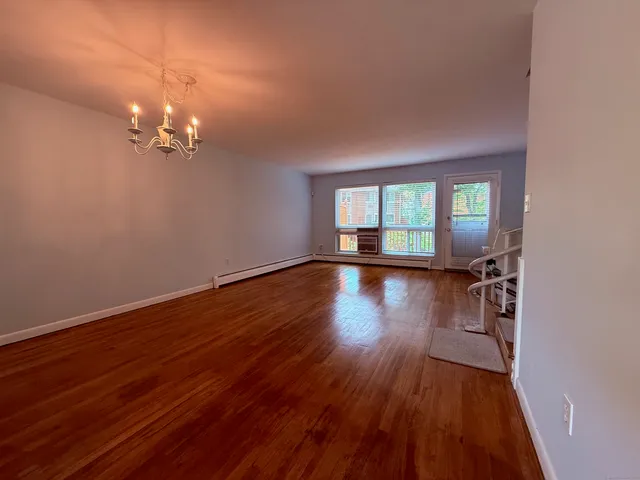 a view of a room with wooden floor and window