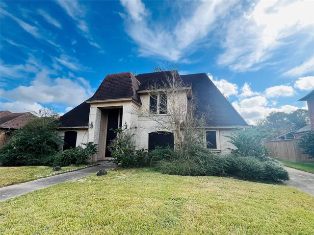 a front view of house with yard and trees around