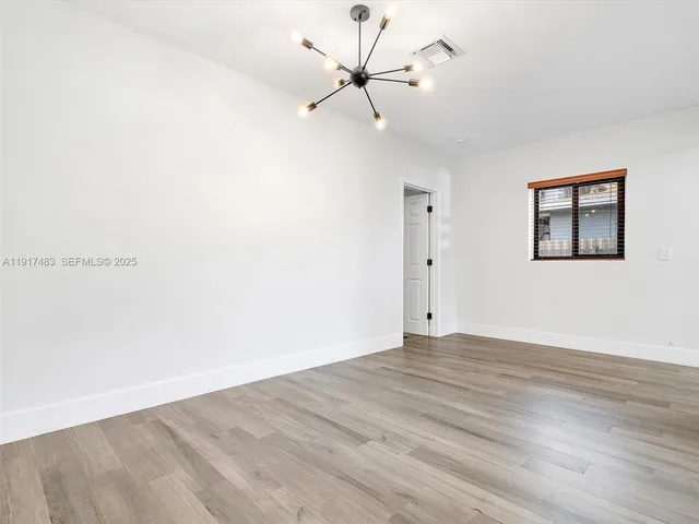 an empty room with fan and windows