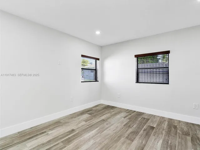 a view of a room with wooden floor and window
