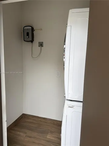 an empty room with wooden floor and mirror