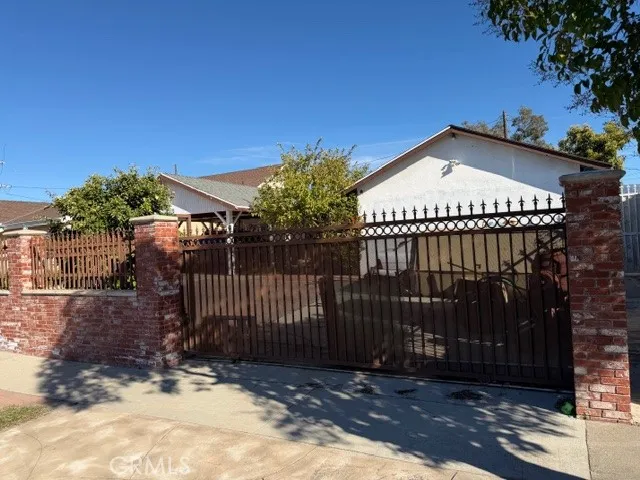 a view of a house with a small yard and wooden fence