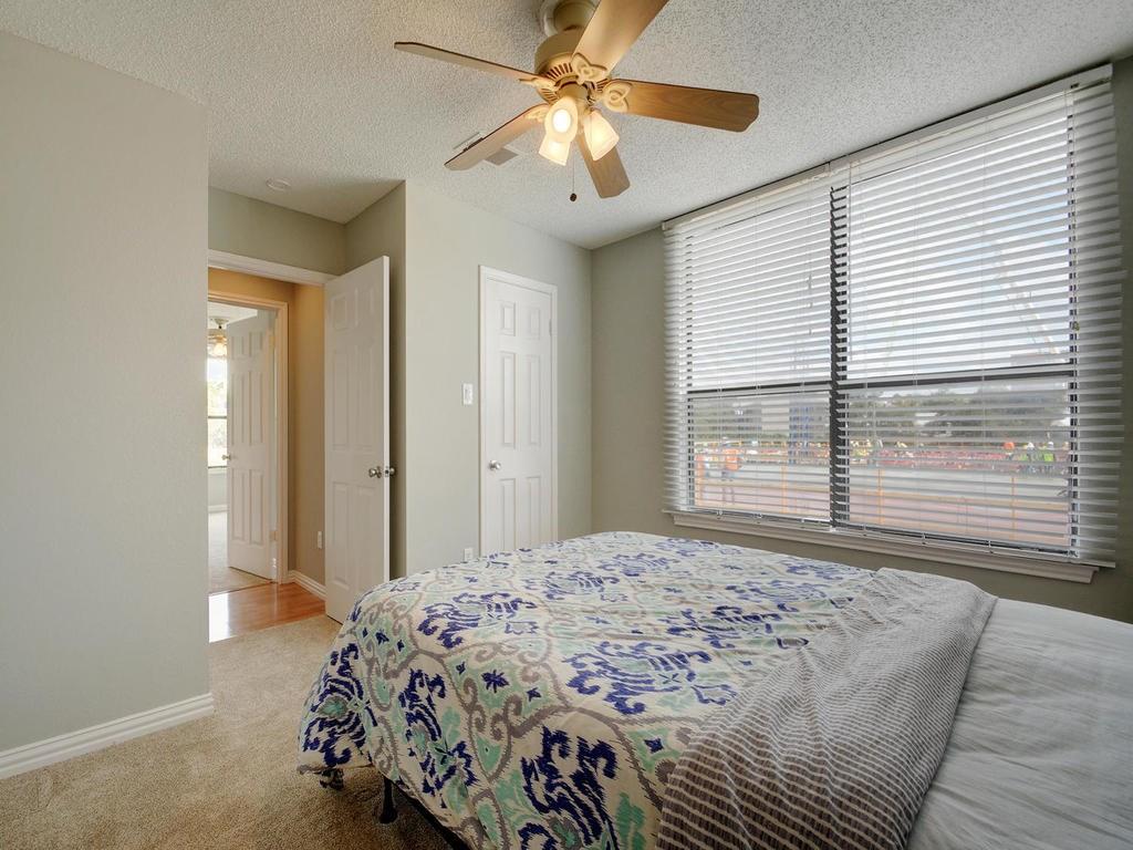 2409 Leon Street, Unit 207 Austin, TX 78705 - Photo 16 of 18 a bedroom with a bed and a chandelier