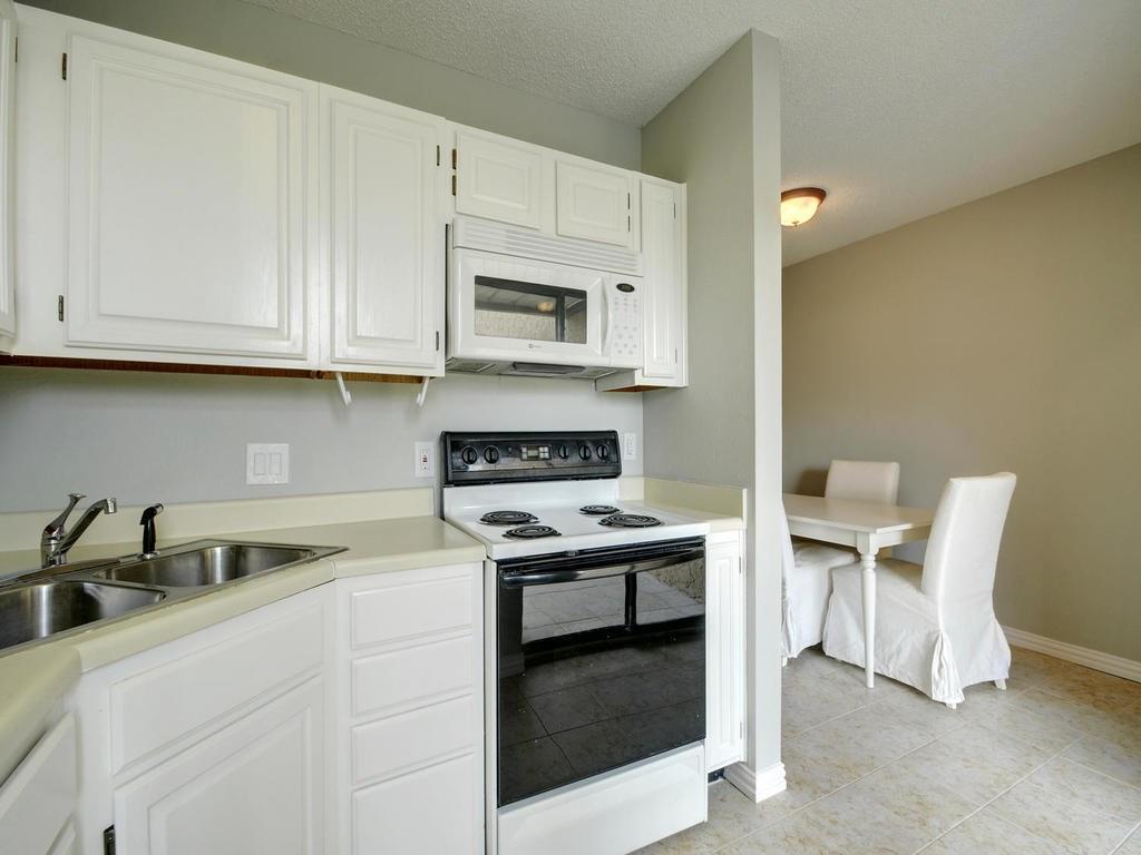 2409 Leon Street, Unit 207 Austin, TX 78705 - Photo 5 of 18 a kitchen with stainless steel appliances granite countertop a sink a stove and white cabinets