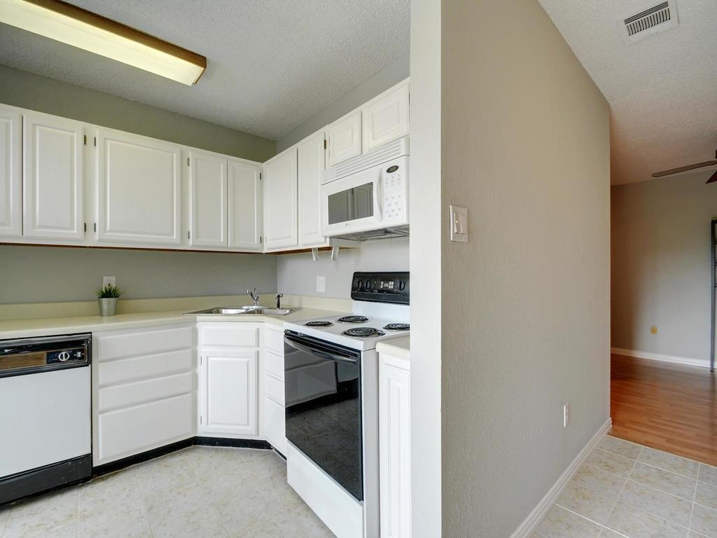 2409 Leon Street, Unit 207 Austin, TX 78705 - Photo 6 of 18 a kitchen with stainless steel appliances granite countertop a stove and a sink