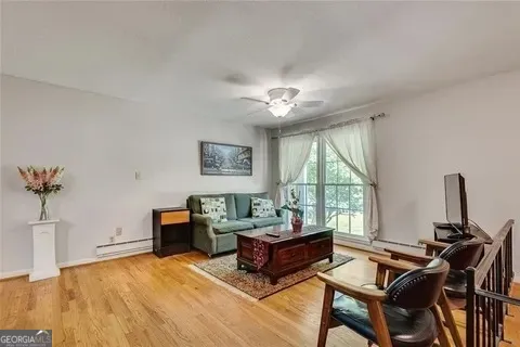 a kitchen with stainless steel appliances granite countertop a refrigerator a stove top oven a dining table and chairs with wooden floor