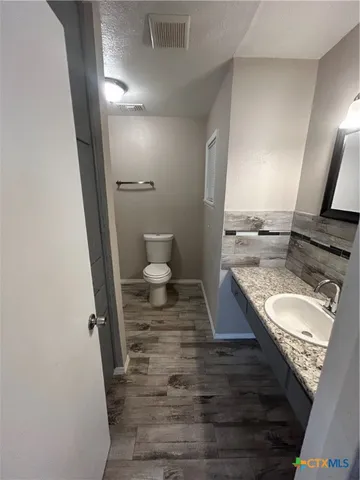 a bathroom with a granite countertop sink and a mirror