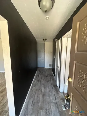 a view of a hallway and wooden floor