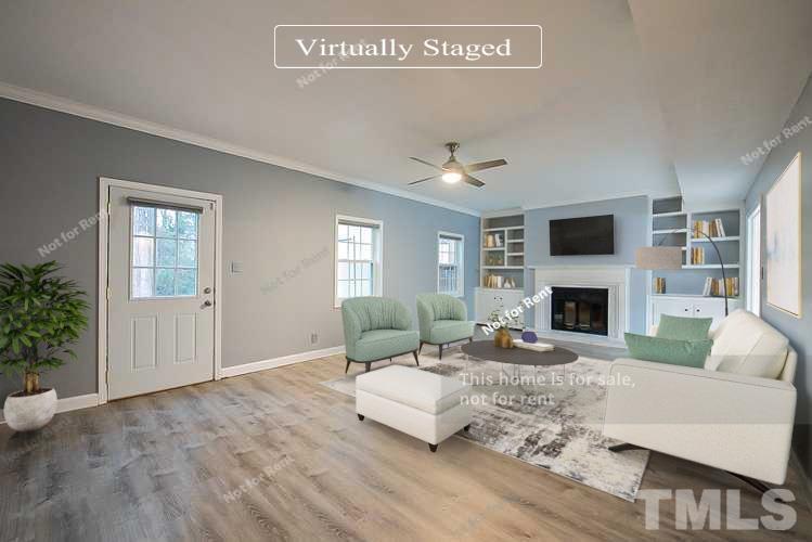 6335 New Market Way, Unit 1 Raleigh, NC 27615 - Photo 2 of 22 a living room with furniture a fireplace and a potted plant