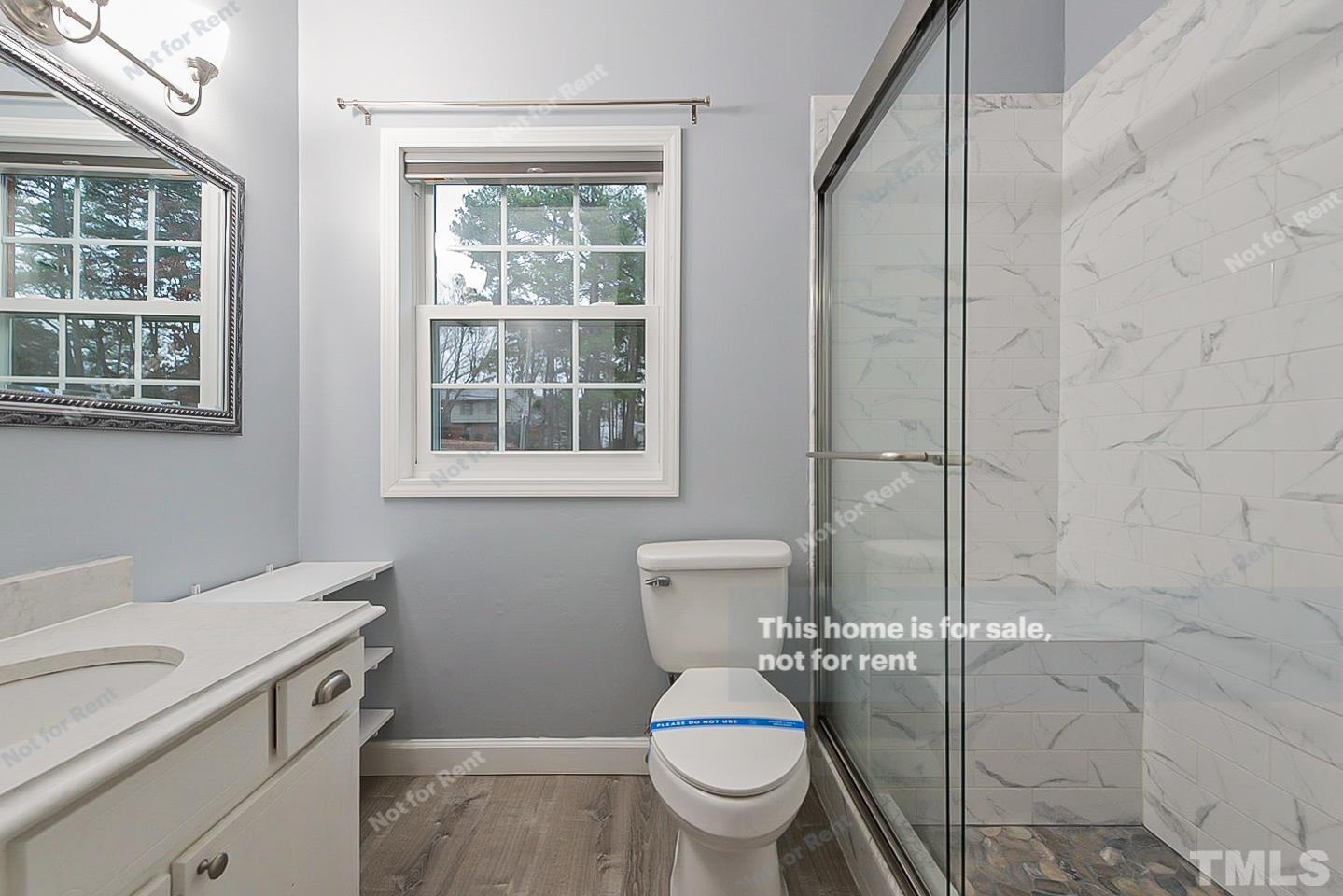 6335 New Market Way, Unit 1 Raleigh, NC 27615 - Photo 20 of 22 a bathroom with a toilet a sink and a shower