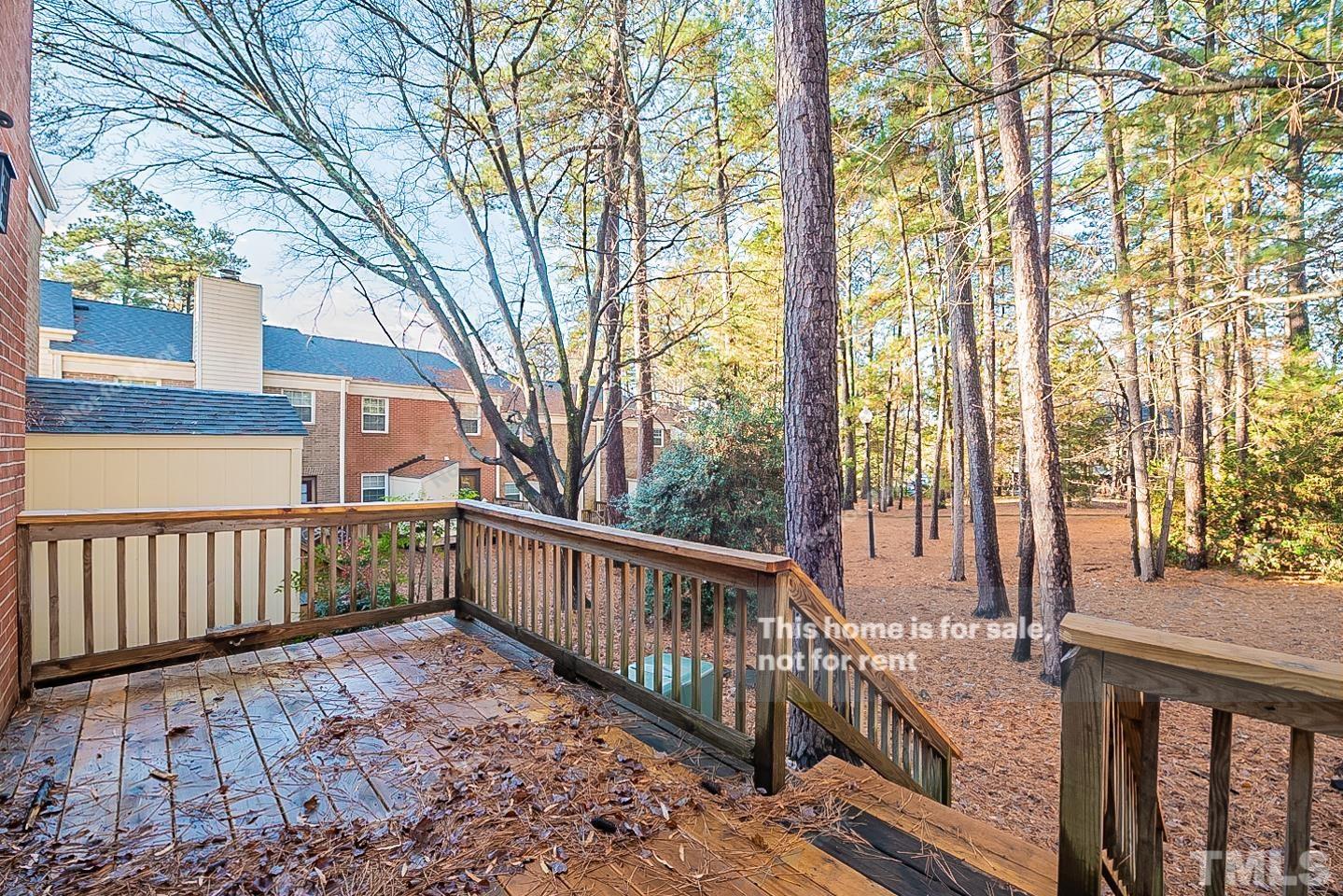 6335 New Market Way, Unit 1 Raleigh, NC 27615 - Photo 21 of 22 a view of a wooden deck with large trees and wooden fence