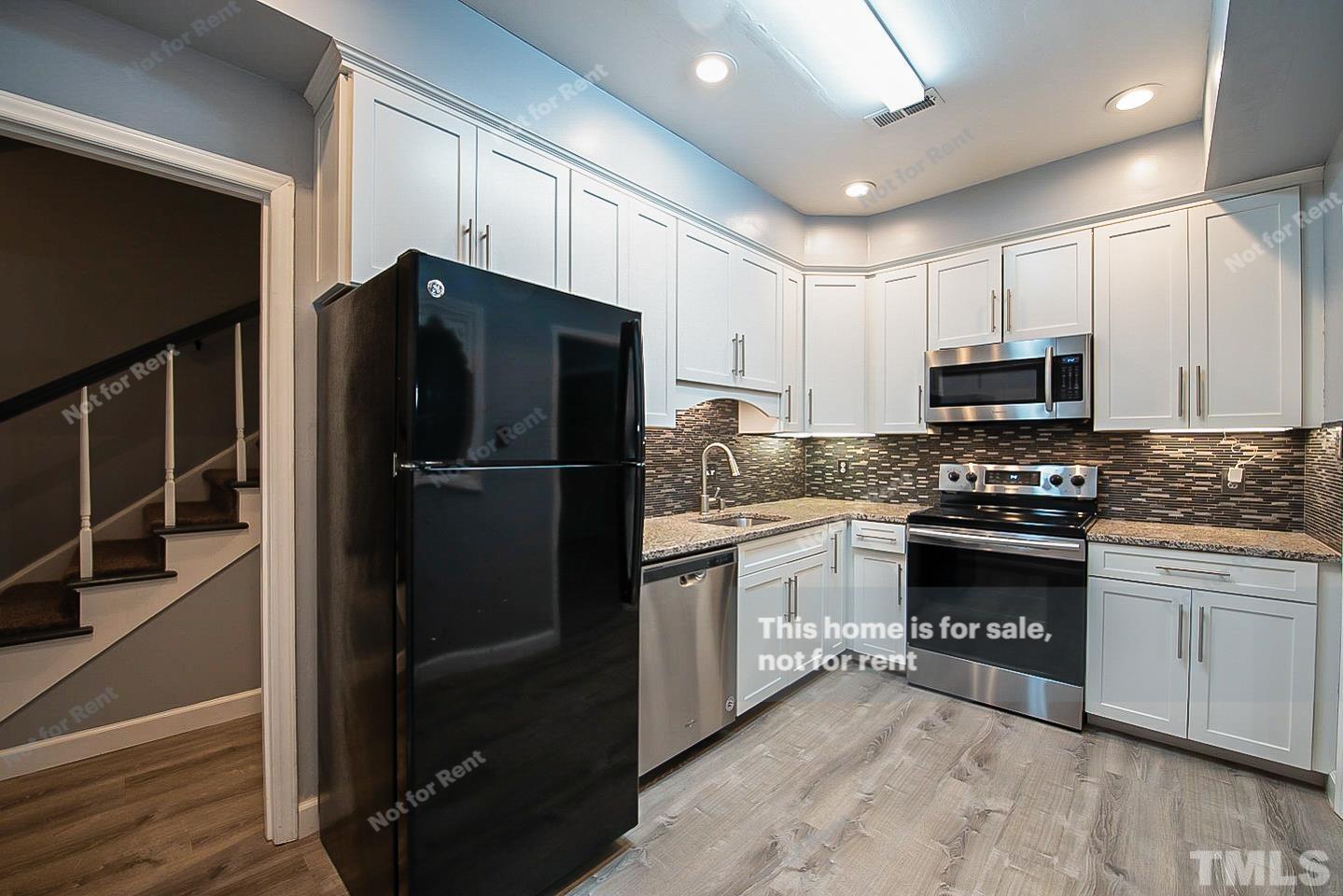 6335 New Market Way, Unit 1 Raleigh, NC 27615 - Photo 4 of 22 a kitchen with granite countertop a refrigerator stove and microwave