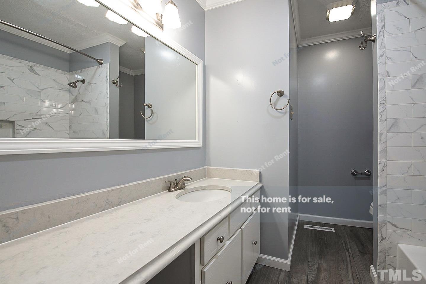 6335 New Market Way, Unit 1 Raleigh, NC 27615 - Photo 6 of 22 a bathroom with a sink and a mirror