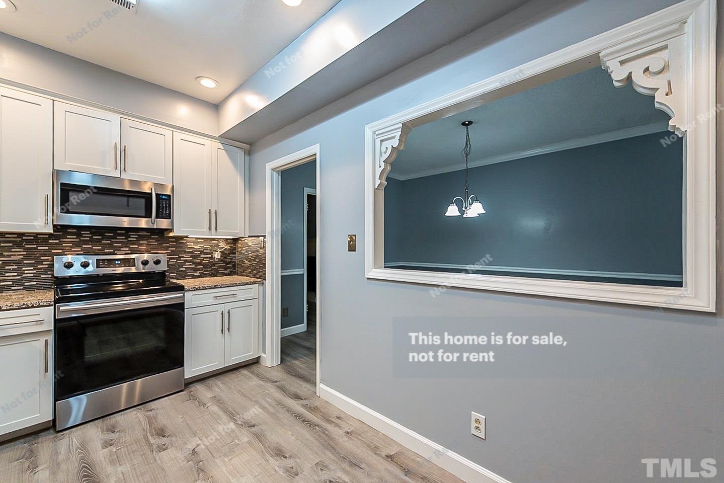 6335 New Market Way, Unit 1 Raleigh, NC 27615 - Photo 8 of 22 a kitchen with stainless steel appliances granite countertop a stove and a microwave