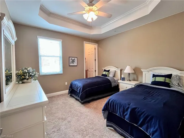 a bedroom with two beds and a chandelier