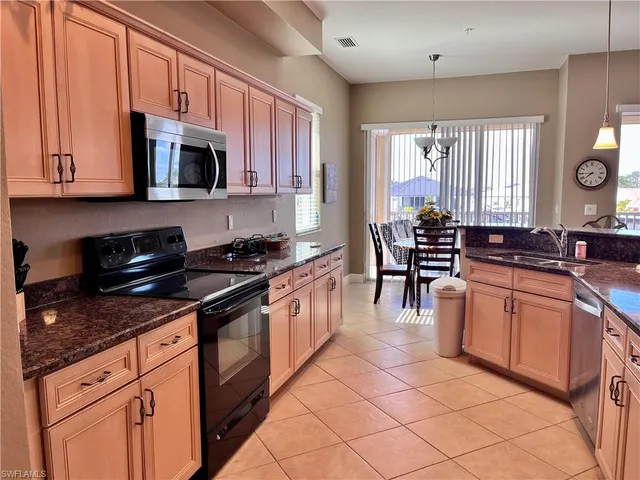 a kitchen with stainless steel appliances granite countertop a stove a sink and a microwave