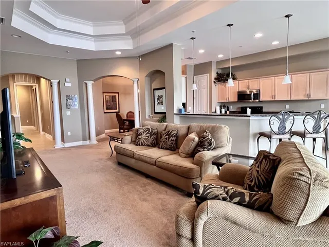 a living room with furniture kitchen and a large window