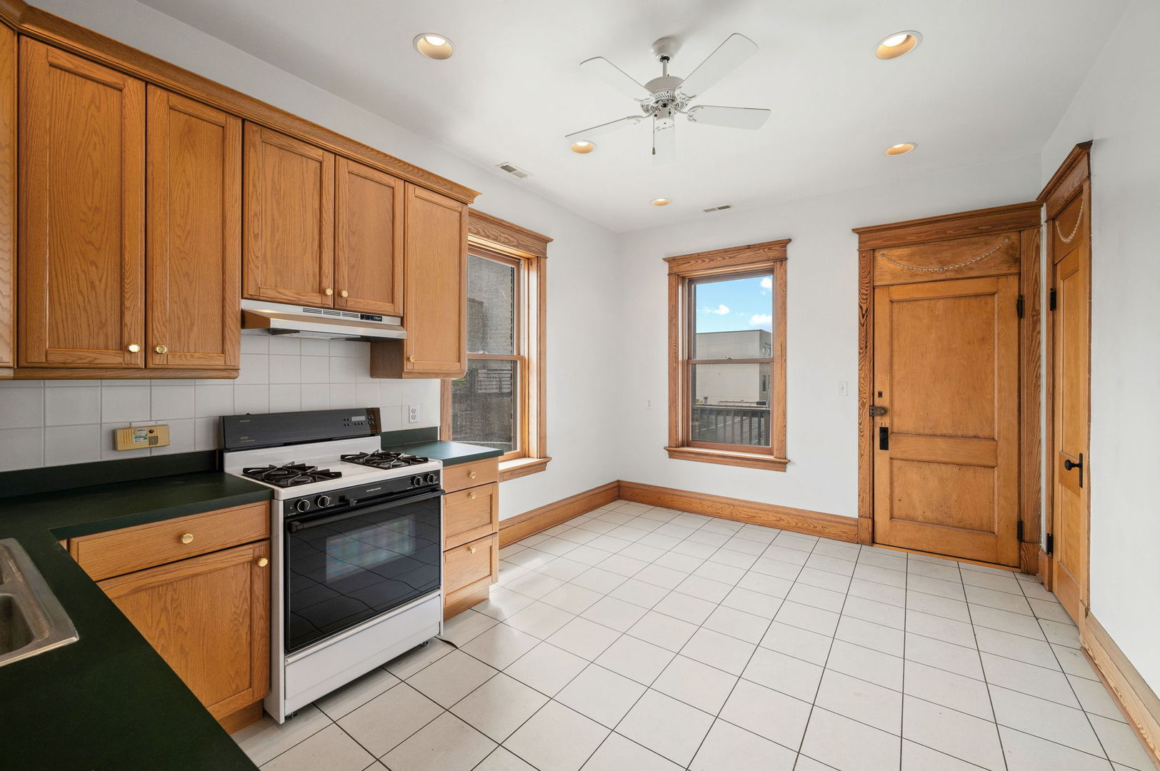 1415 West George Street Chicago, IL 60657 - Photo 27 of 35 a kitchen with stainless steel appliances granite countertop a stove a sink and a refrigerator