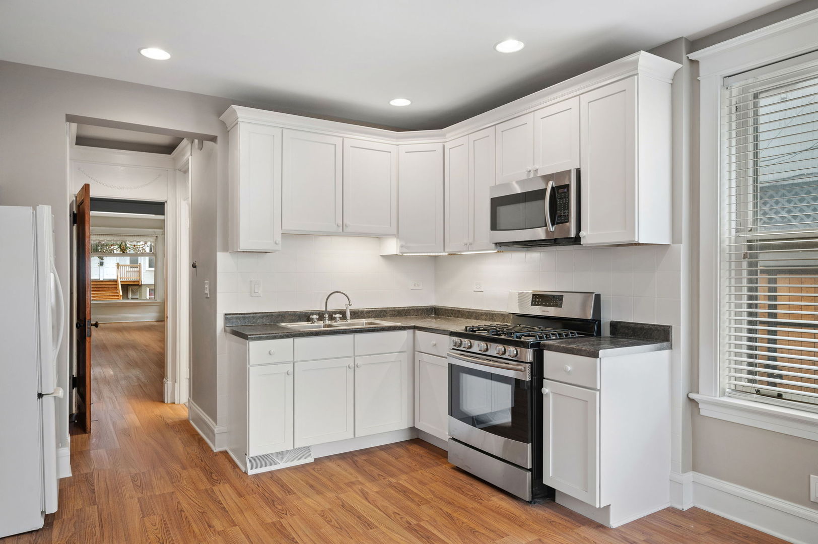 1415 West George Street Chicago, IL 60657 - Photo 7 of 35 a kitchen with stainless steel appliances granite countertop a stove a sink and a microwave