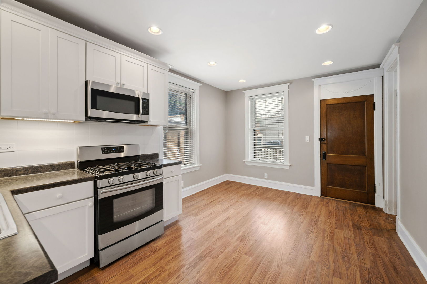 1415 West George Street Chicago, IL 60657 - Photo 8 of 35 a kitchen with stainless steel appliances granite countertop a stove a microwave and sink