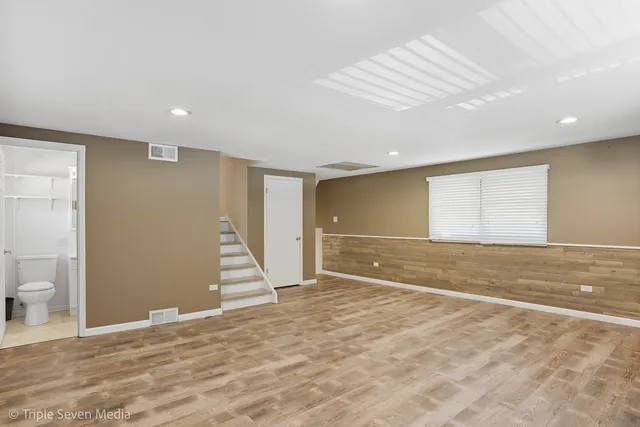 a view of a hallway with wooden floor and stairs