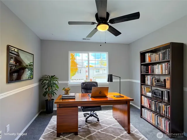 a view of a workspace with a bookshelf and a window