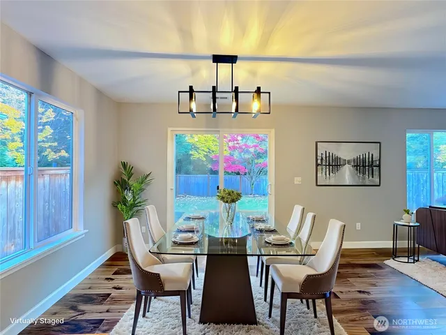 a view of a dining room with furniture a chandelier and wooden floor