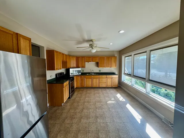 a kitchen with stainless steel appliances granite countertop a refrigerator and a sink