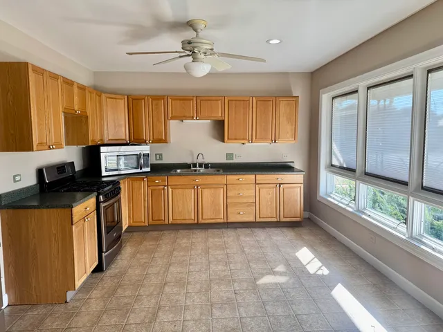 a kitchen with stainless steel appliances granite countertop a stove a sink and a refrigerator