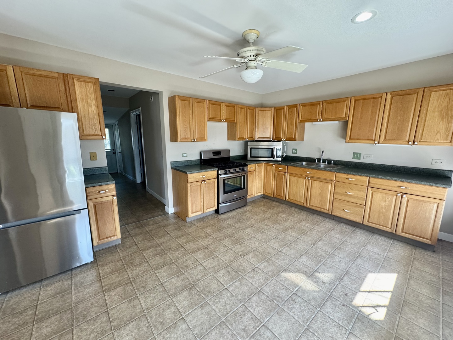 110 North Elm Street Waterman, IL 60556 - Photo 10 of 16 a kitchen with stainless steel appliances granite countertop a refrigerator a sink a stove a dining table and chairs