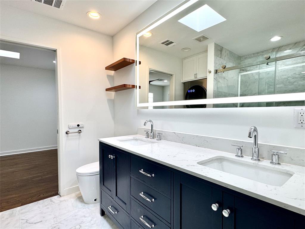4134 Travis Street, Unit 2 Dallas, TX 75204 - Photo 15 of 28 a bathroom with a double vanity sink and a toilet